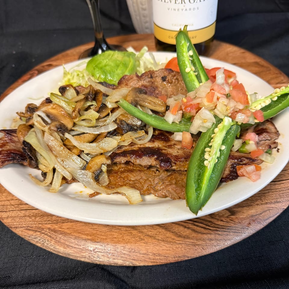 Grilled steak with sautéed onions and mushrooms, topped with pico de gallo and jalapeños.