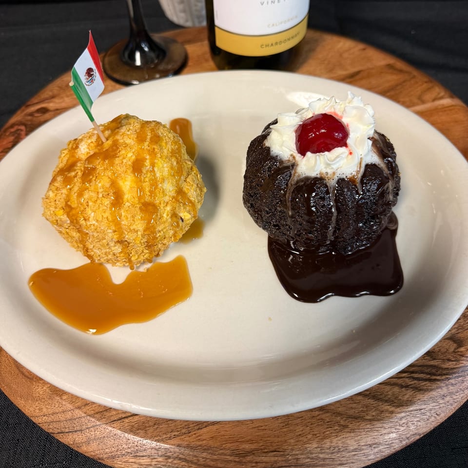Fried ice cream with a Mexican flag and a chocolate lava cake with whipped cream and a cherry.